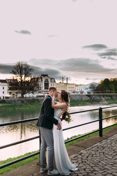 Чоловік і дружина обіймаються і цілуються на березі річки . — стокове фото