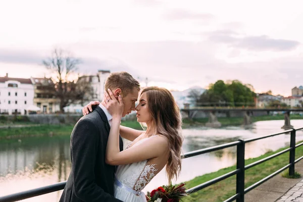 Чоловік і дружина обіймаються і дивляться один на одного біля річки — стокове фото