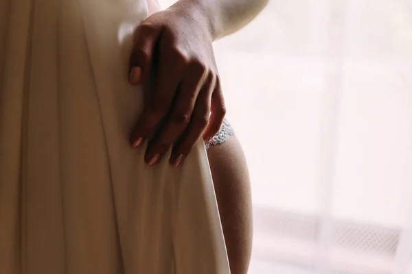 La novia se aferra a la cintura probándose un vestido de novia . —  Fotos de Stock