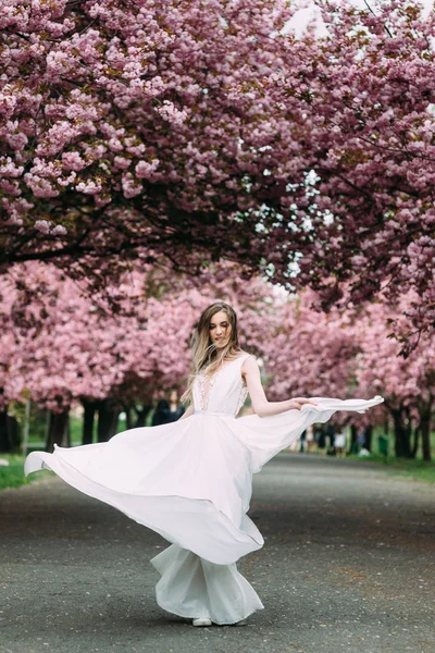 charming bride dances under the romantic flowering tree.