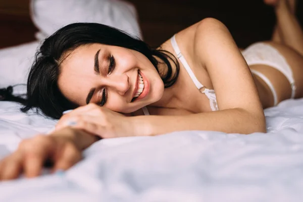 Un gran comienzo del día, una joven hermosa chica está tumbada en el sofá y tomando el sol en la cama — Foto de Stock