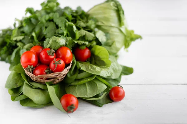 美味的蔬菜食品，红色和多汁的西红柿附近的绿色沙拉的叶子 — 图库照片