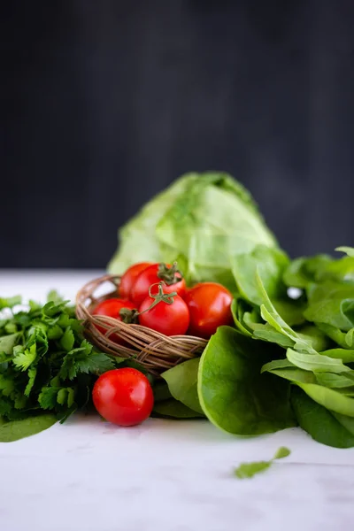 Raw vegetables are on the table, a red ripe and juicy tomato, next to it are other sources of vitamins — Stock Photo, Image