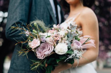 gelin ve damat düğün günü bir düğün buketi tutarak