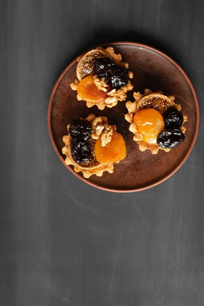 Auf einem Holzteller drei Cupcakes mit gesunden Früchten Zwetschgenaprico — Stockfoto