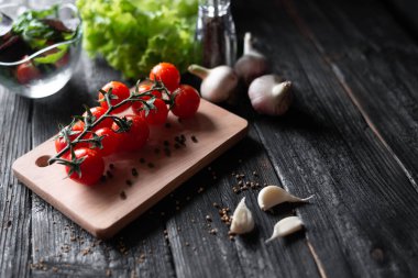 siyah ahşap retro masada kiraz domates sarımsak baharat yalan 