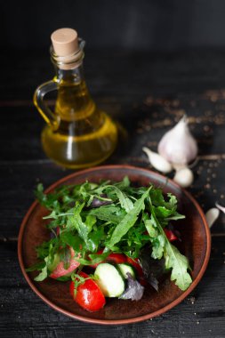 çiğ gıda vitamin vitamini salatası kil plaka domates salatalık fesleğen arugula üzerine koydu