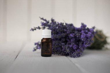 yanında kahverengi bir şişe kokulu lavanta esansiyel yağı çiçek bir buket.