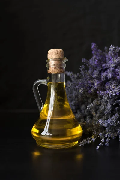 glass bottle with fragrant lavender oil on the background of a p