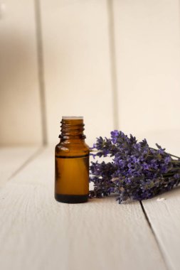 kokulu lavanta yağı ve çiçek bir buket ile kahverengi cam şişe.