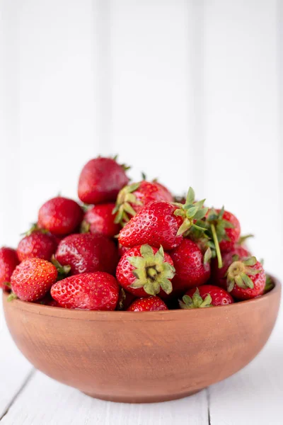 Fresas maduras y jugosas están en un plato sobre la mesa. vitaminas y minerales en el mismo plato —  Fotos de Stock
