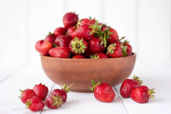 Primer plano de las fresas maduras, el fondo de las tablas blancas. Escritorio, comida vegetariana —  Fotos de Stock