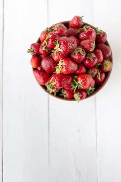 Nuovo raccolto di fragole su un piatto, bacche succose e deliziose sono sul tavolo — Foto Stock