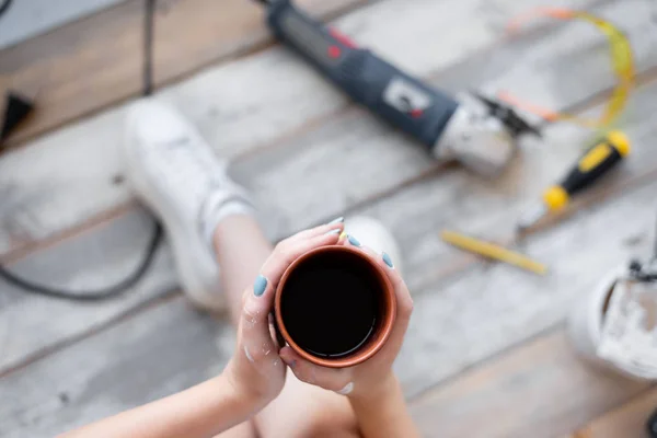 Foto de cima de perto de uma xícara com café nas mãos de uma jovem . — Fotografia de Stock