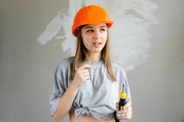 elinde bir tornavida ile turuncu bir kask bir inşaat sitesinde kız