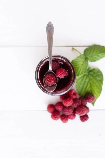 Marmellata di lamponi fatta in casa con lamponi freschi sul tavolo di legno bianco. vista dall'alto — Foto Stock