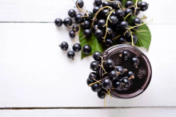 Ripe black currant on a jar of jam. grocery, food preparation process — Stock Photo, Image