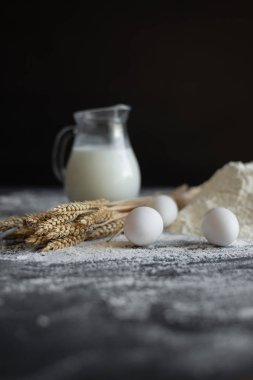 ekmek yapmak için tarifi, malzemeler masada yatıyor. Un ve yumurta, bir dekantör içinde süt