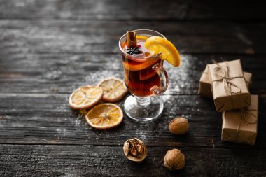 Noel ahşap bir rustik masada baharat ve meyve ile kırmızı şarap mulled.