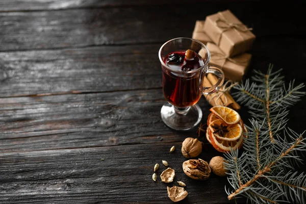 Kieliszek smacznego i pachnące grzane wino na drewnianym stole, suche plastry pomarańczowe leżą na stole, orzech i anyżu — Zdjęcie stockowe