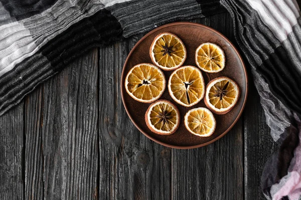 Jullov, bordsdekoration, skivor av torrt doftande orange på ett träbord — Stockfoto