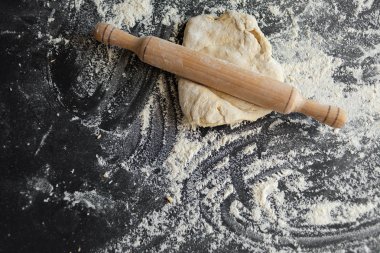 siyah bir arka plan üzerinde hamur kabuk, pizza pişirme kavramı, ahşap oklava