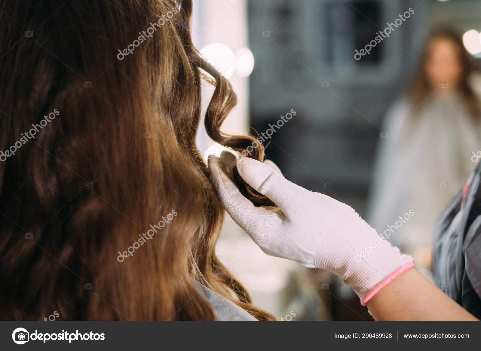 The Hairdresser Makes Curls To The Client The Female Hand Holds