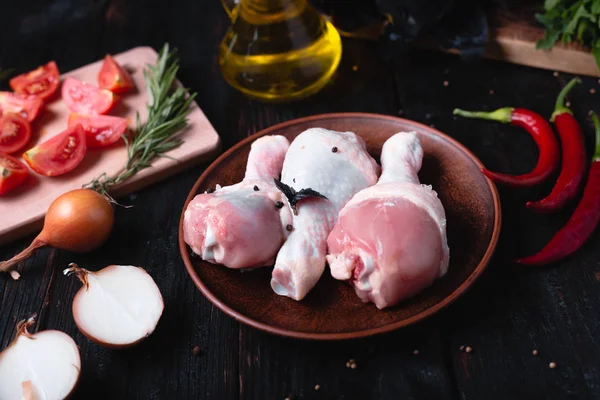 Syrové kuřecí stehna leží na talíři, lahodné aromatické koření, pálivé papriky a česnek — Stock fotografie