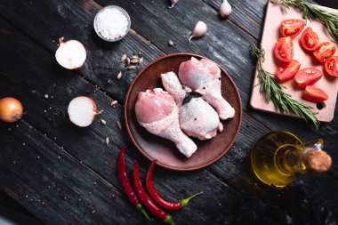bir tabakta taze tavuk bacakları, masada ızgara et, aromatik baharat lar ve otlar hazırlamak