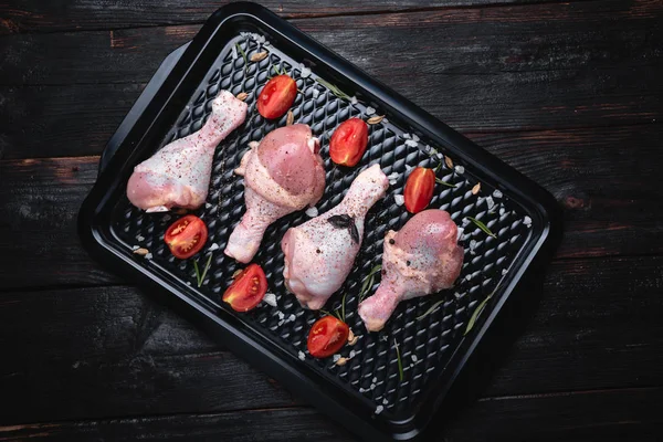 Tabakta taze çiğ tavuk bacağı aranjmanı. Üstte görüntü.