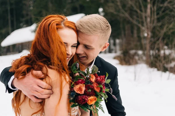 Grappig en gelukkige bruid en bruidegom lachen en genieten van het leven. Redhead meisje en Guy blond. Winter bruiloft. — Stockfoto