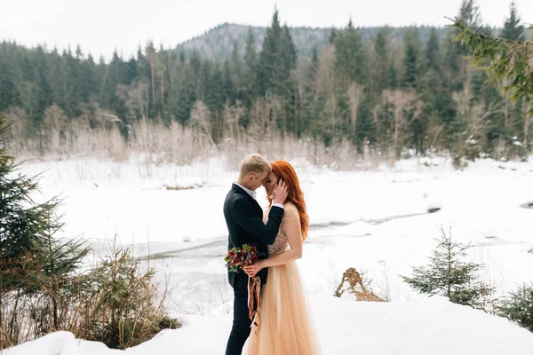 Elegante joven hermosa pareja, novia y novio, nieve de invierno miente, boda en la estación fría — Foto de Stock