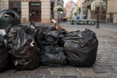Siyah çöp torbaları şehrin sokaklarında yatıyor.