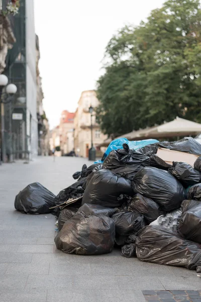 a pile of rubbish lies on the street, full of bags and dirt