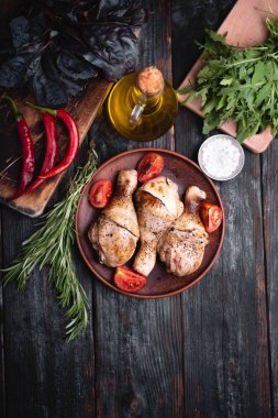 Izgara tavuk bacağı, tabağa uzan, et için aromatik otlar ve baharatlar.