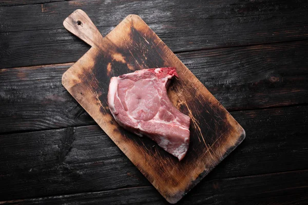 A fresh piece of pork lies on a cutting board. Raw piece of meat, ingredient for dinner — Stock Photo, Image