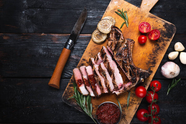 a delicious juicy piece of grilled meat, vegetables on the table, a delicious dinner for the whole family.