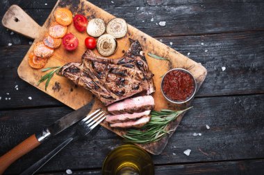 Izgara striploin Taş Masa üzerinde kesme tahtası üzerinde biftek dilimlenmiş.