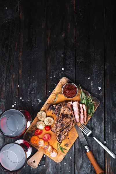 Sabroso pedazo de carne en una tabla de cortar, carne a la parrilla, salsa aromática con especias, lugar para el texto , —  Fotos de Stock