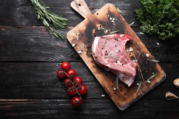 Kesme tahtasında taze et, masada çiğ biftek. Et için baharatlar — Stok fotoğraf