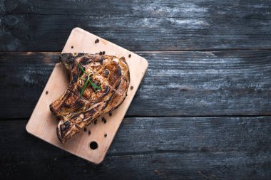 Bir parça kızarmış sulu biftek kesme tahtasının üzerinde duruyor. Mesajın için bir yer. Lezzetli ve güzel kokulu bir akşam yemeği.