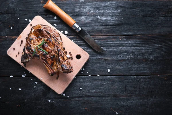 Köstlich duftendes Steak liegt auf einem Schneidebrett, ein scharfes Messer für eine Wanderung, Gewürze und Salz. — Stockfoto