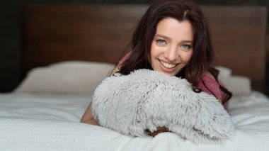 Yatak odasında genç ve çekici bir kadın var. Dalgalı saçlı bir esmer gün boyunca bir otel odasında yatıyor. Yatakta yatan mutlu bir kadının portresi..