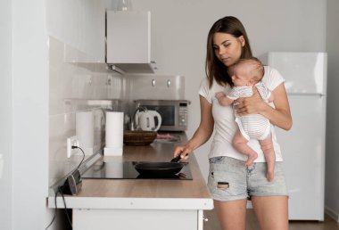 Doğum izni mi? Genç anne küçük oğluyla yemek hazırlıyor, mutfak içi, boş yer.