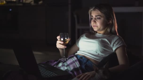 兴奋的女人喝酒 在家里看电视上看悲伤的电影 一个人坐在沙发上 不快乐的年轻人 负面的情绪和电视观念 — 图库视频影像