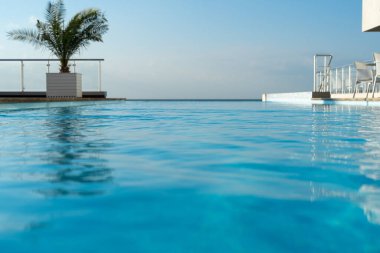 Lüks otel villasının sonsuzluk havuzundaki muhteşem turkuaz suyun düşük açılı çekimi. Tatil konsepti. Cennet, tropikal rahatlama