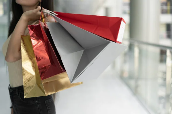 在女性手中的购物袋的特写 在时装店的广告购物 女性的手拿着红白相间的包裹 购物中心 复制空间 — 图库照片