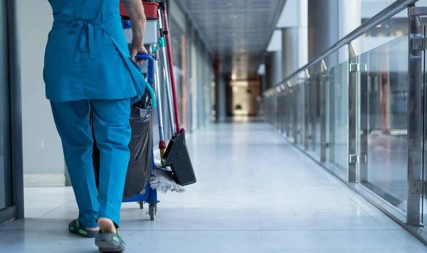 Een Werkneemster Speciale Kleding Rolt Een Trolley Voor Het Schoonmaken — Stockfoto