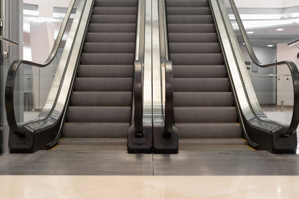 Escalator store empty in the mall two lanes up and down. Without people