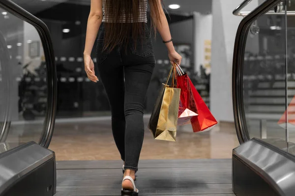 一个手里拿着纸袋的女人离开了自动扶梯 购物中心的概念 黑色星期五 — 图库照片
